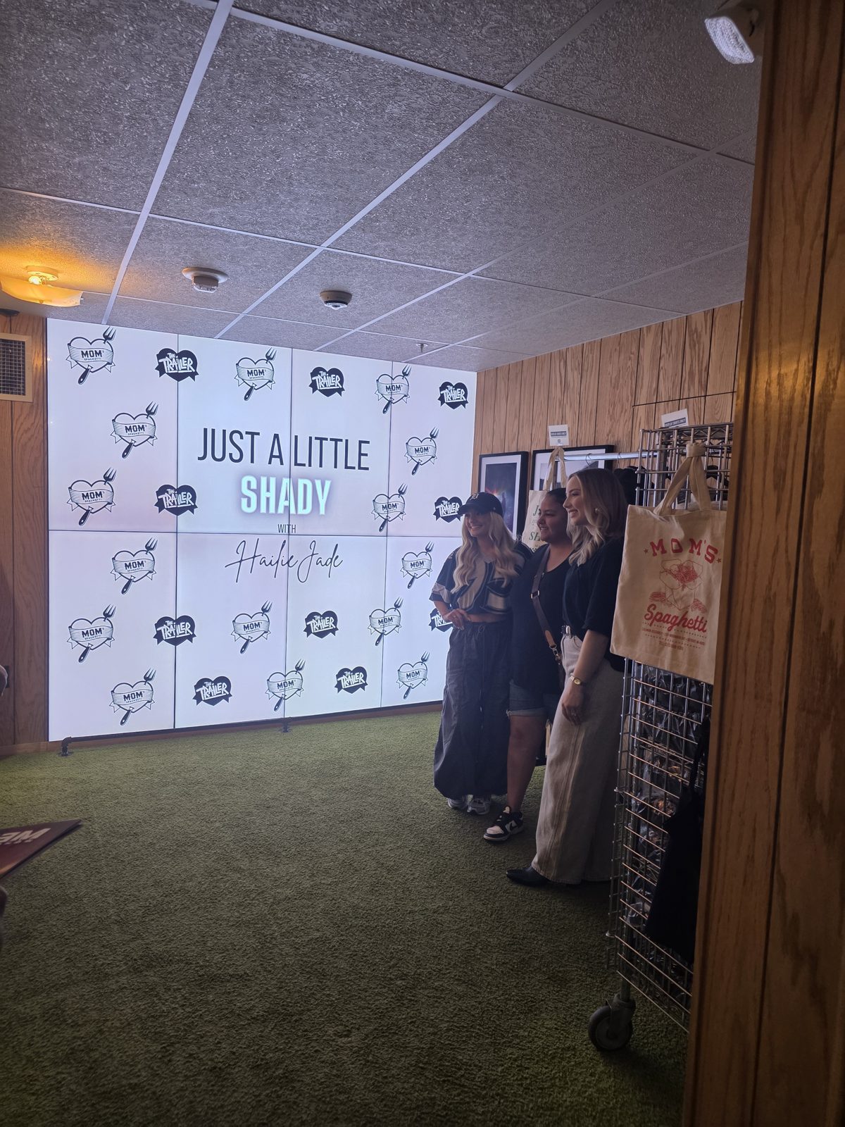 Hailie Jade posing with fans in front of the Just a Little Shady with Hailie Jade wall at Mom's Spaghetti