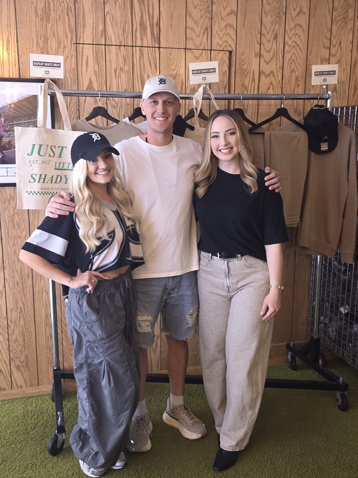 Brad Mines with Hailie Jade and a friend by the Just a Little Shady merch rack at Mom's Spaghetti