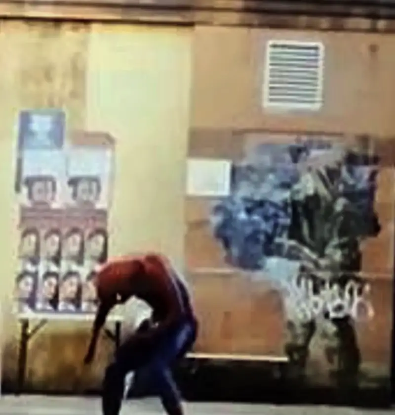 A blurry frame from Spider-Man: Brand New Day showing Spider-Man crouched beside a wall covered in posters and a dark mural — the frame fans claim depicts B-Rabbit from 8 Mile